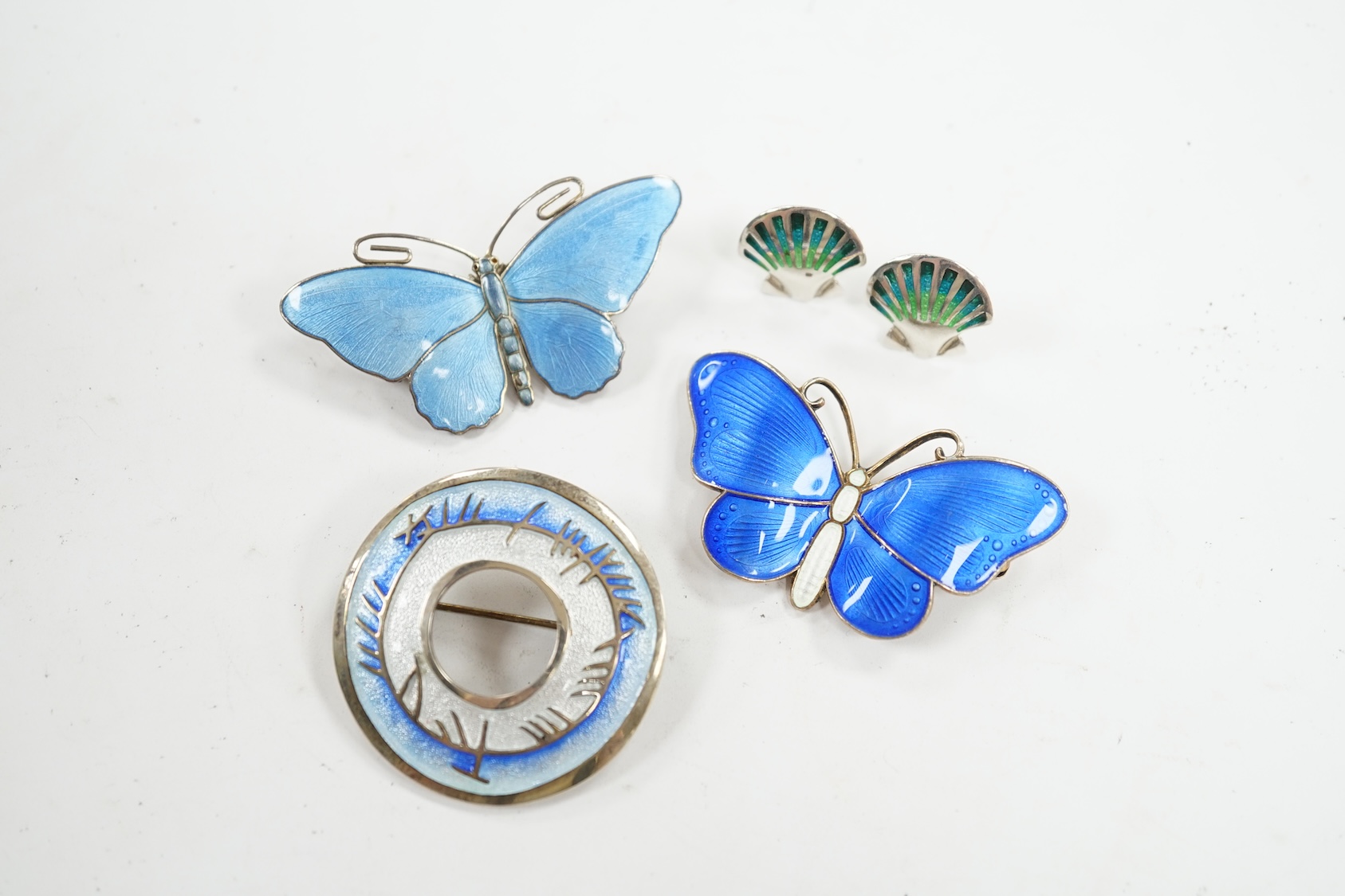 Two Scandinavian gilt white metal and enamel butterfly brooches, largest 52mm, together with a white metal and enamel circular brooch and a pair of earrings. Condition - fair to good